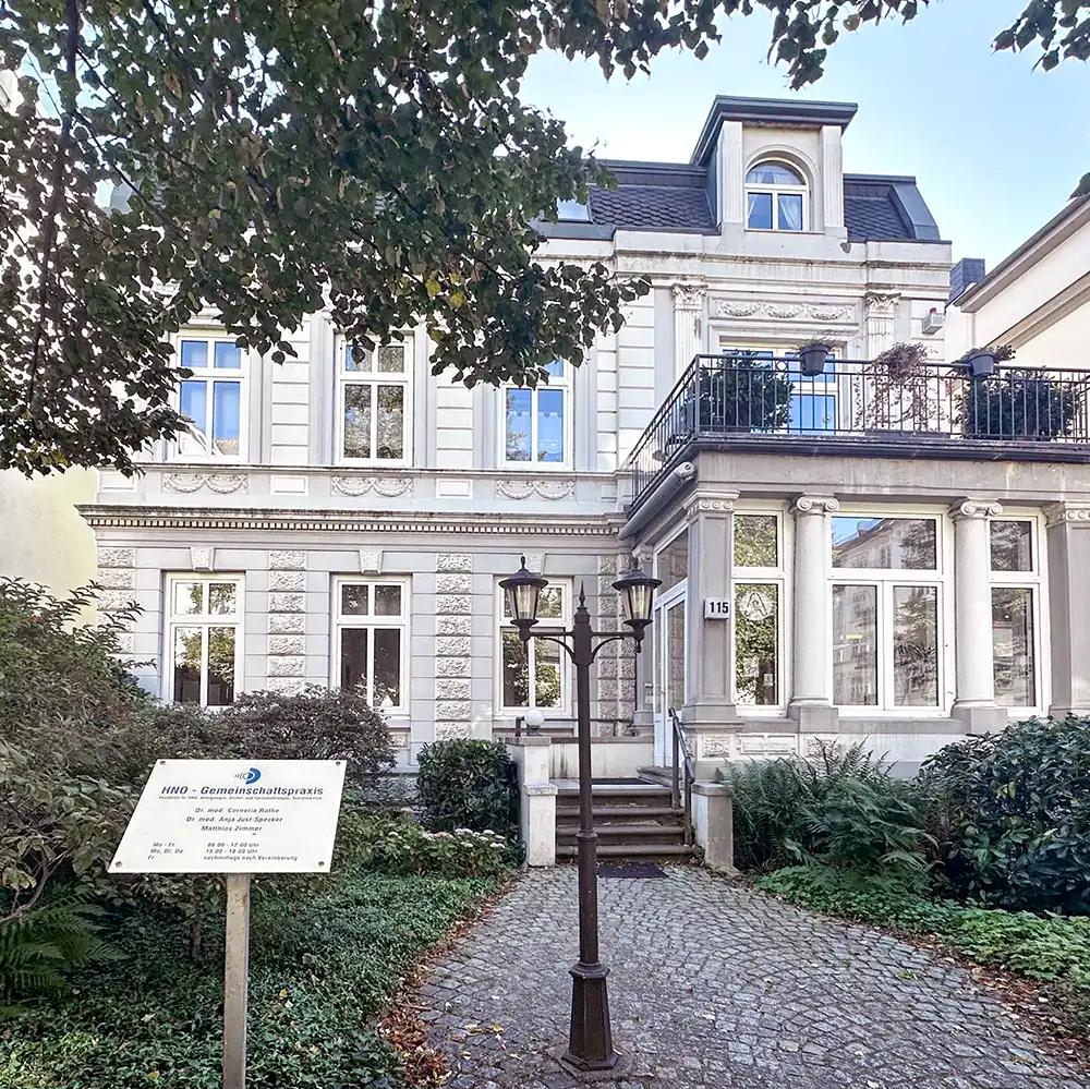 Weiß-graue Jugendstilvilla in Hamburg, in der sich die HNO-Praxis Bismarckstraße befindet, mit historischen architektonischen Details und großen Fenstern.