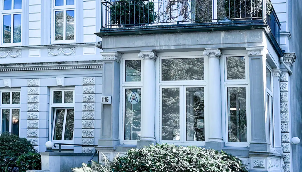 Eingang der HNO-Praxis Bismarckstraße mit historischen architektonischen Details und großen Fenstern.